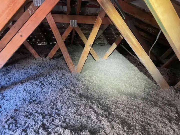 Thick grey cellulose fibre insulation packed evenly between roof trusses under a tiled roof, Comfort Zone, Lawnton QLD