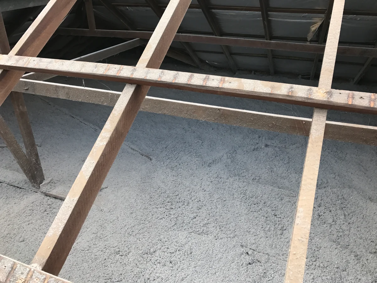 Cellulose insulation laid evenly across the ceiling cavity between the timber trusses, filled level with the top plates. A standard 120 mm pump like this gets you about R3.0, right over the tops of the joists with no gaps.