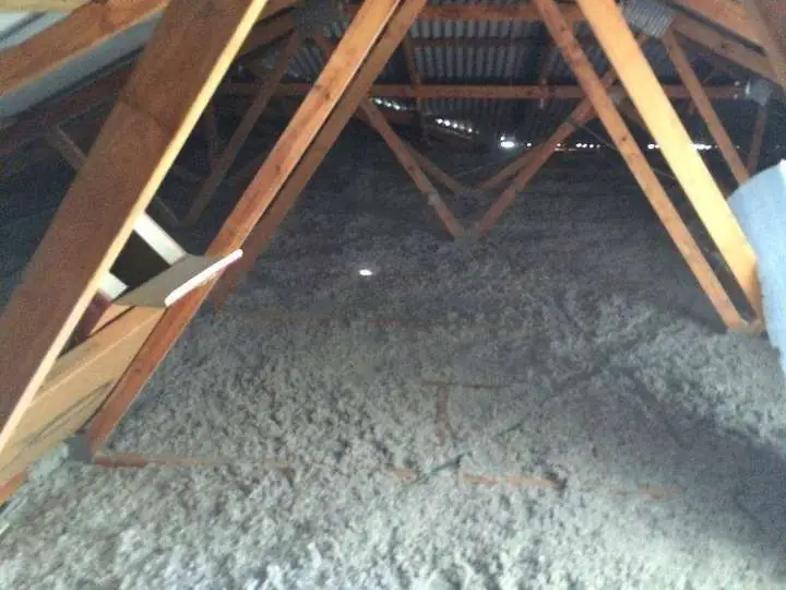 Seamless grey cellulose insulation laid flush across ceiling joists under a metal roof, Comfort Zone install