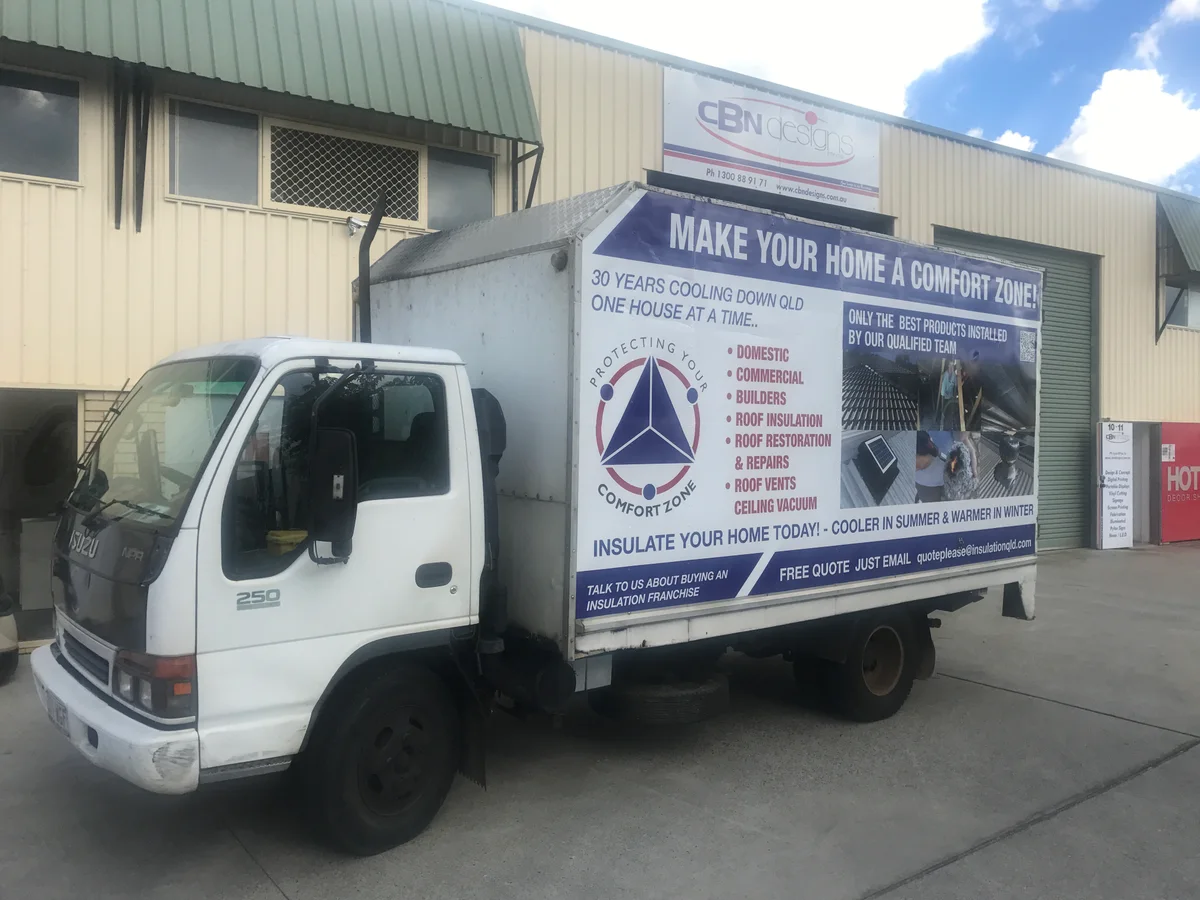 The Comfort Zone Insulation service truck, a white Isuzu box truck signwritten 'Make Your Home A Comfort Zone' with domestic, commercial, builders, roof insulation, roof restoration and repairs listed down the side.