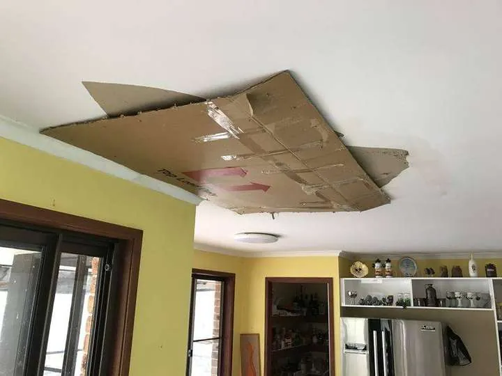 A kitchen ceiling with roof-leak water damage contained to one small patch where cellulose held it, instead of spreading across the ceiling