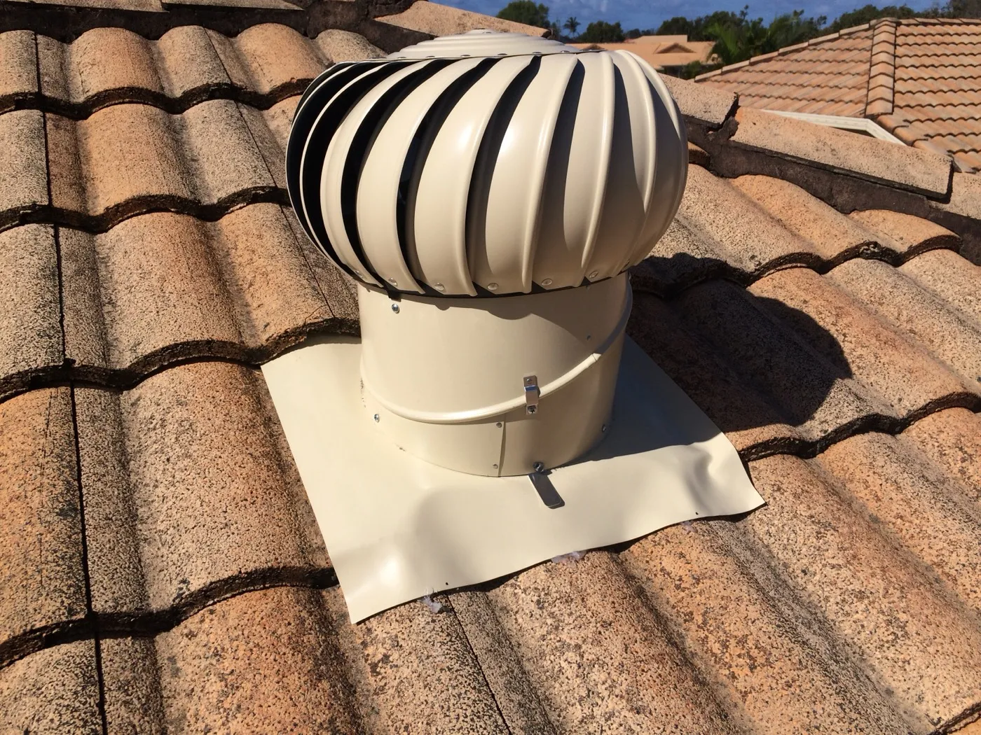 A new whirlybird vent fitted on a tiled Pottsville roof to pull hot air out of the roof space before cellulose fibre insulation goes in