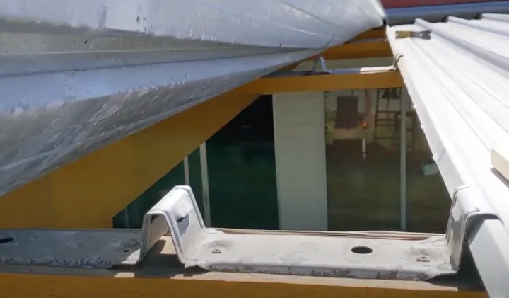 A white ClipLok standing-seam metal roof beside a skylight, interlocking sheets used on very flat roofs