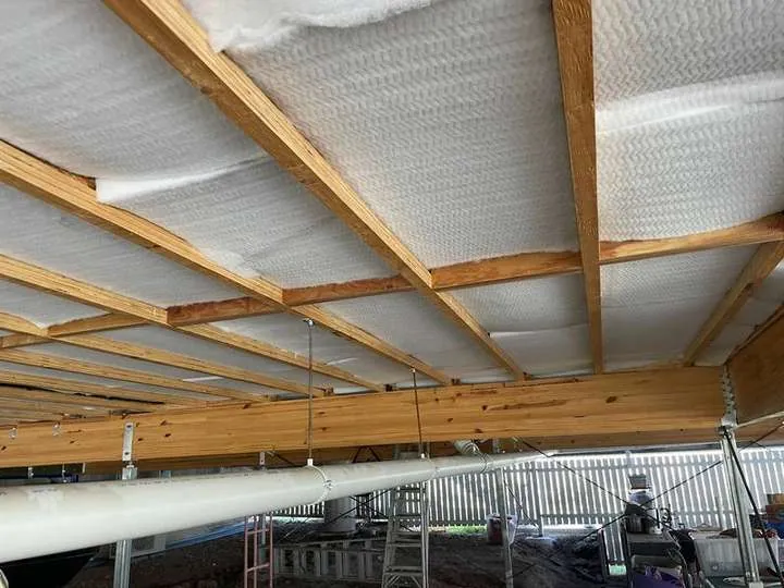 Stiffer white polyester underfloor batts pushed into place between joists, no fixings needed, Blacksoil