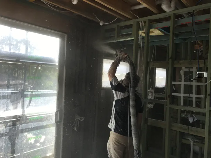 Wet-spray cellulose fibre being applied to a wall during construction, Comfort Zone's own manufactured product