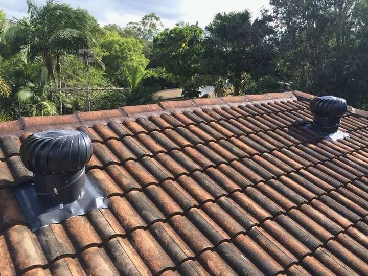 Two black whirlybird roof vents on a terracotta-tile roof that still needed insulating, because vents alone don't cool a roof, Woodford QLD